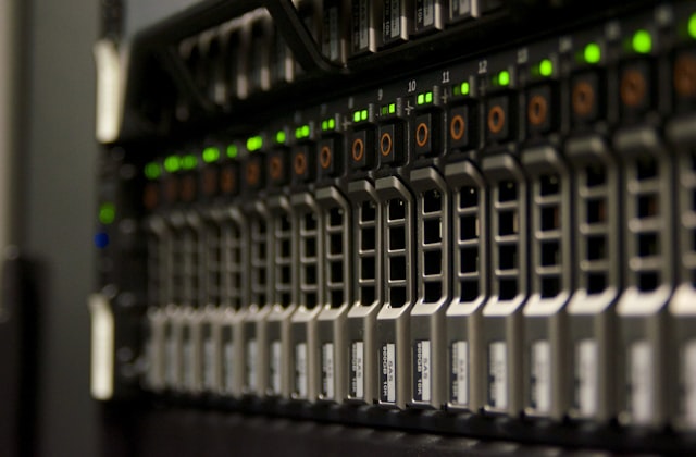 Rows of server drive bays with green status lights inside a data center