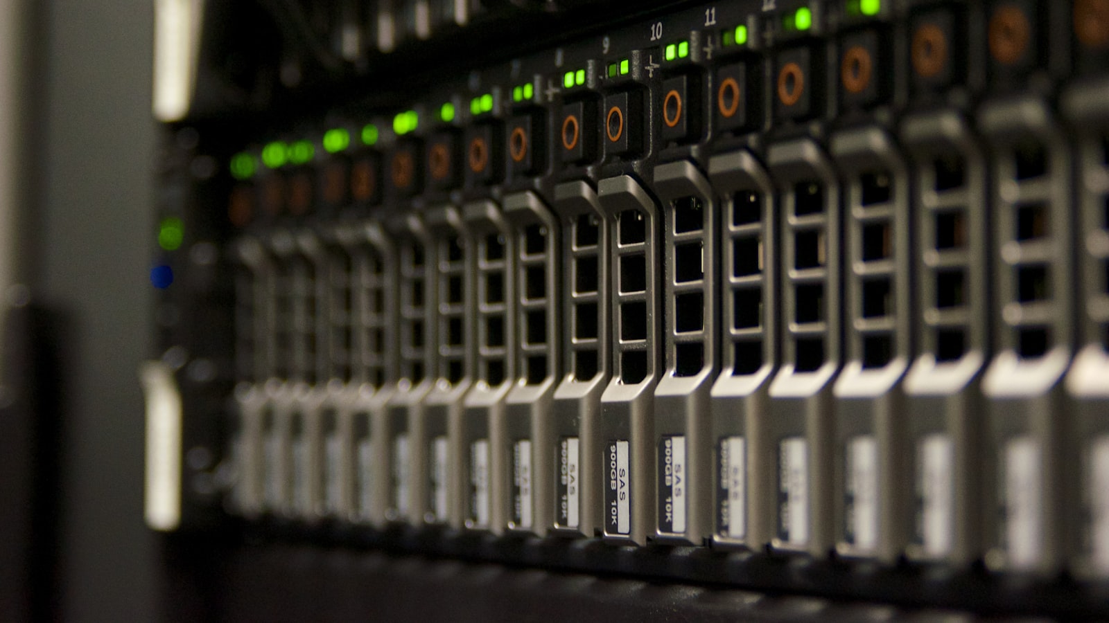 Rows of server drive bays with green status lights inside a data center