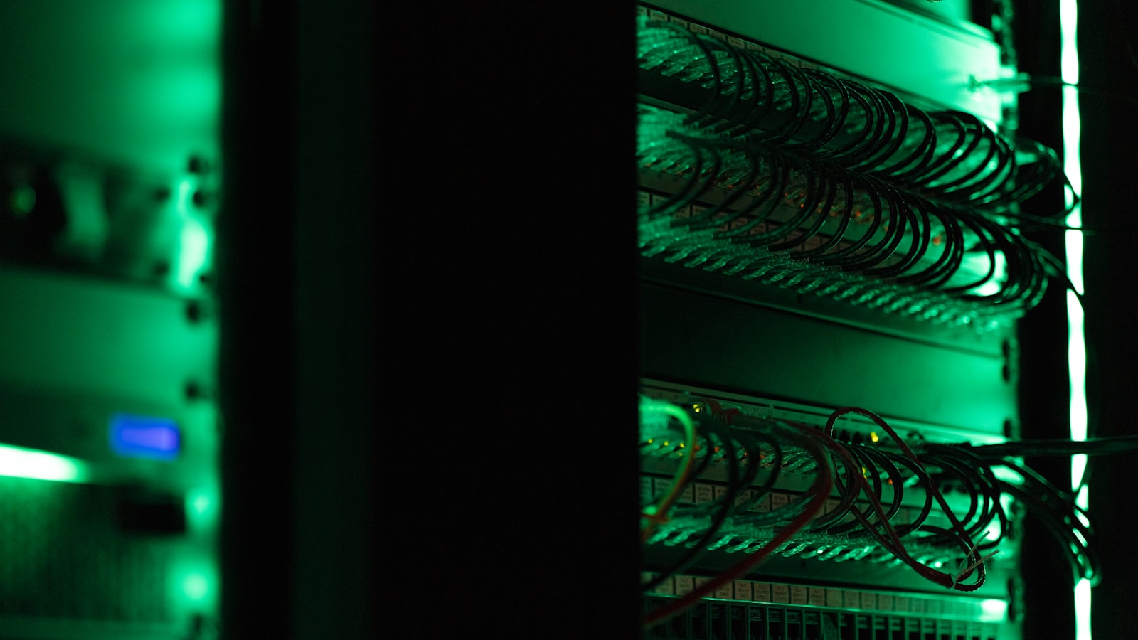 Server racks with status lights in a dark data centre